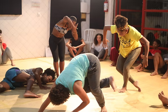 Grupo de pessoas participando de uma oficina de expressão corporal em um espaço cultural.